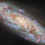 Hubble Captures a Tilted Spiral Galaxy Ablaze with Baby Stars and Glowing Gas